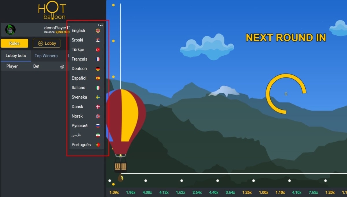 Language selection menu for Hot Balloon game, showing 12 language options including English, Srpski, Türkçe, Français, and others. The background shows a red and yellow hot air balloon against a mountain landscape with blue sky.